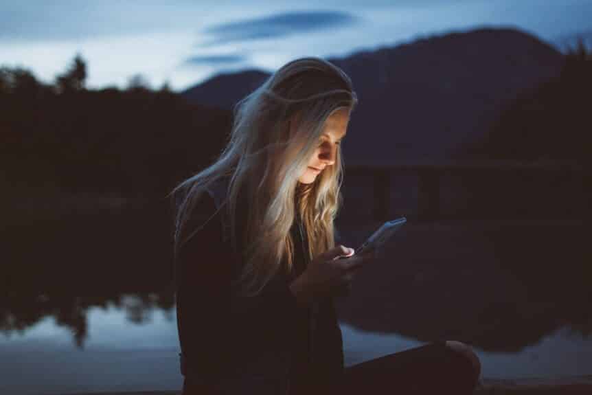 Is social media impacting your mental health? A girl looking at her phone in nature hosted by Wellin5 in Vancouver, BC.